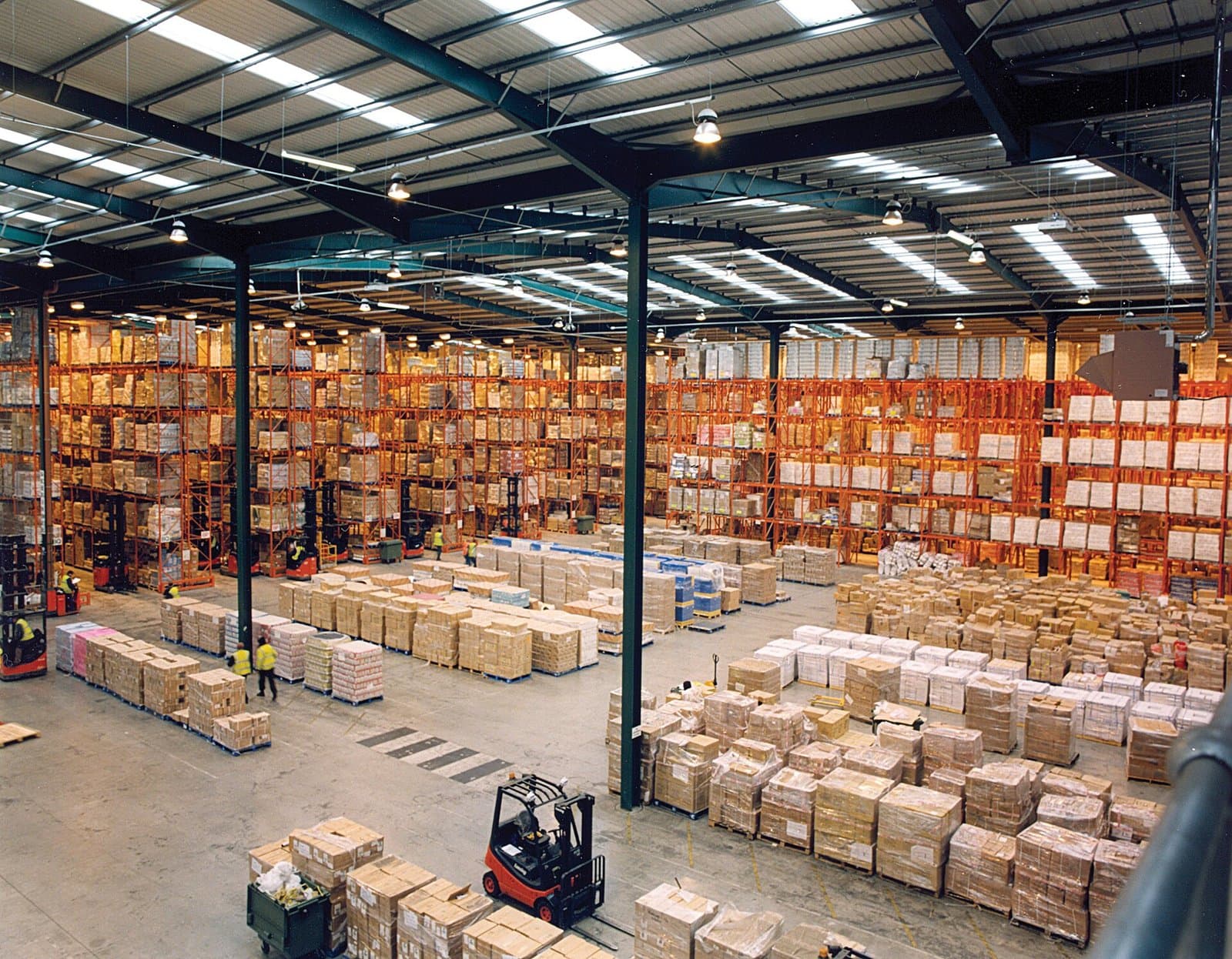 Distribution warehouse with loaded steel pallet racking and a forklift in the aisle